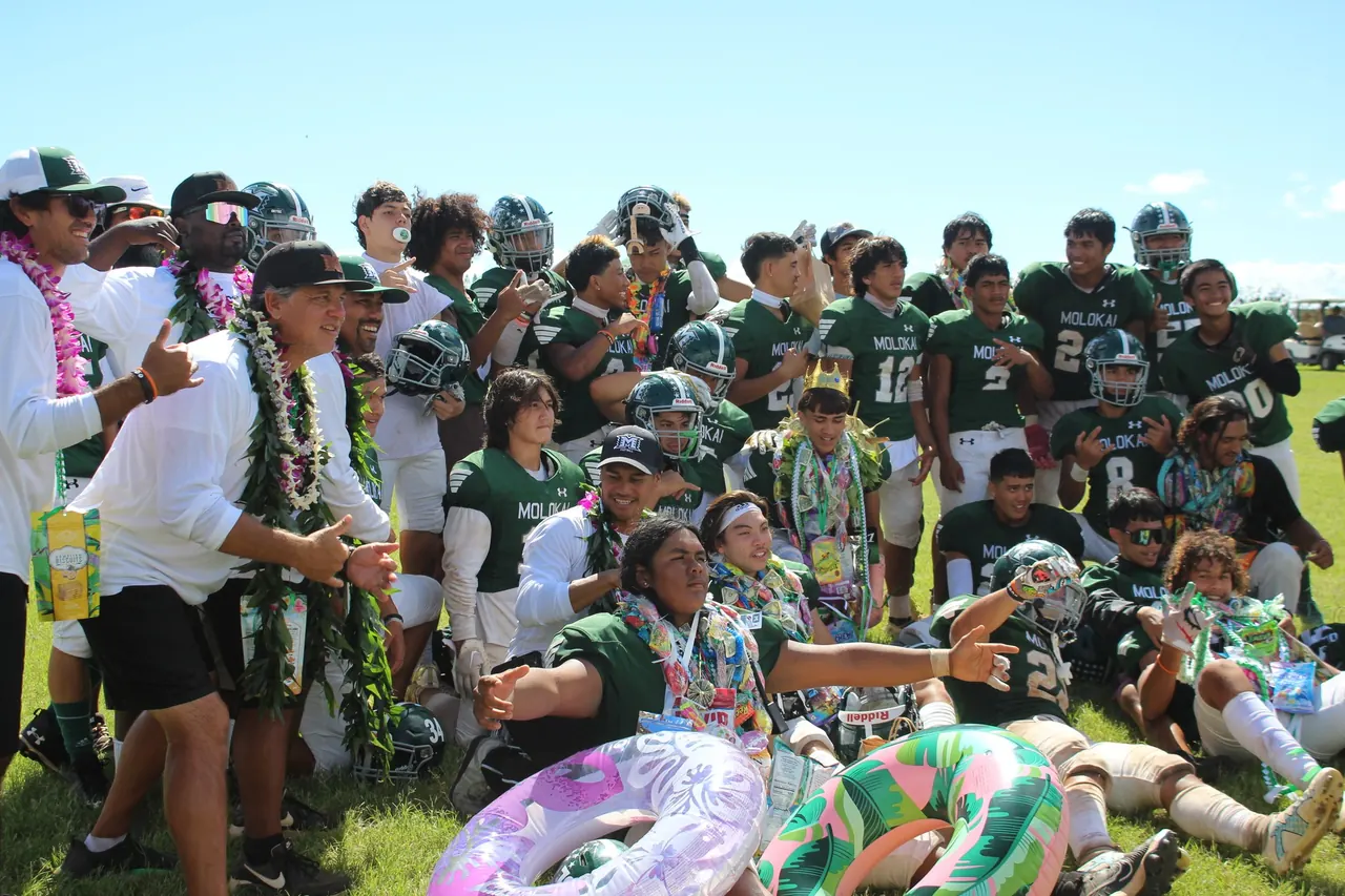 Molokaʻi Farmers football players and coaches celebrating with lei after a game