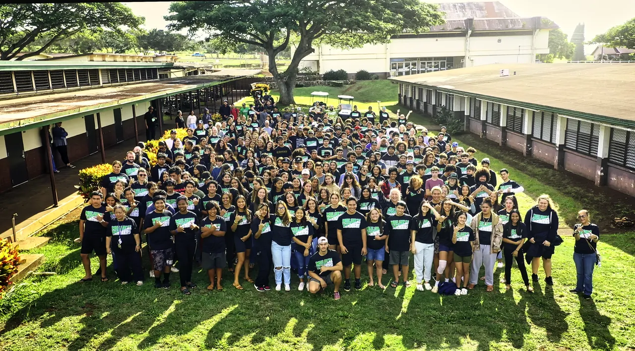 Molokaʻi High School students gathered on the campus lawn in matching Farmers shirts